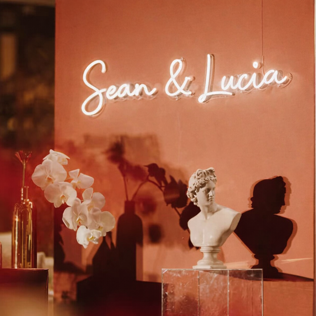 Custom wedding neon sign with “Sean & Lucia” in LED light with floral backdrop