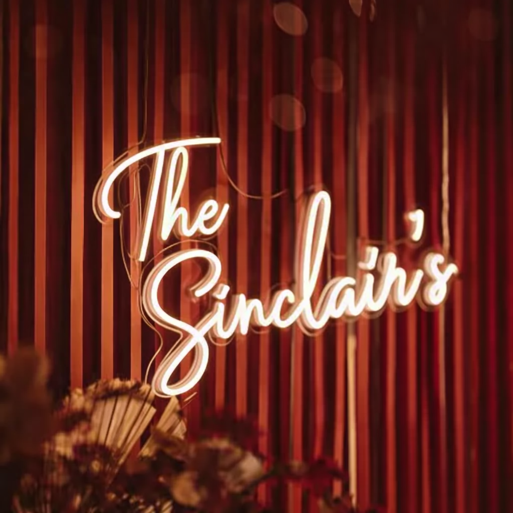 “The Sinclairs” custom neon sign in cursive LED lettering